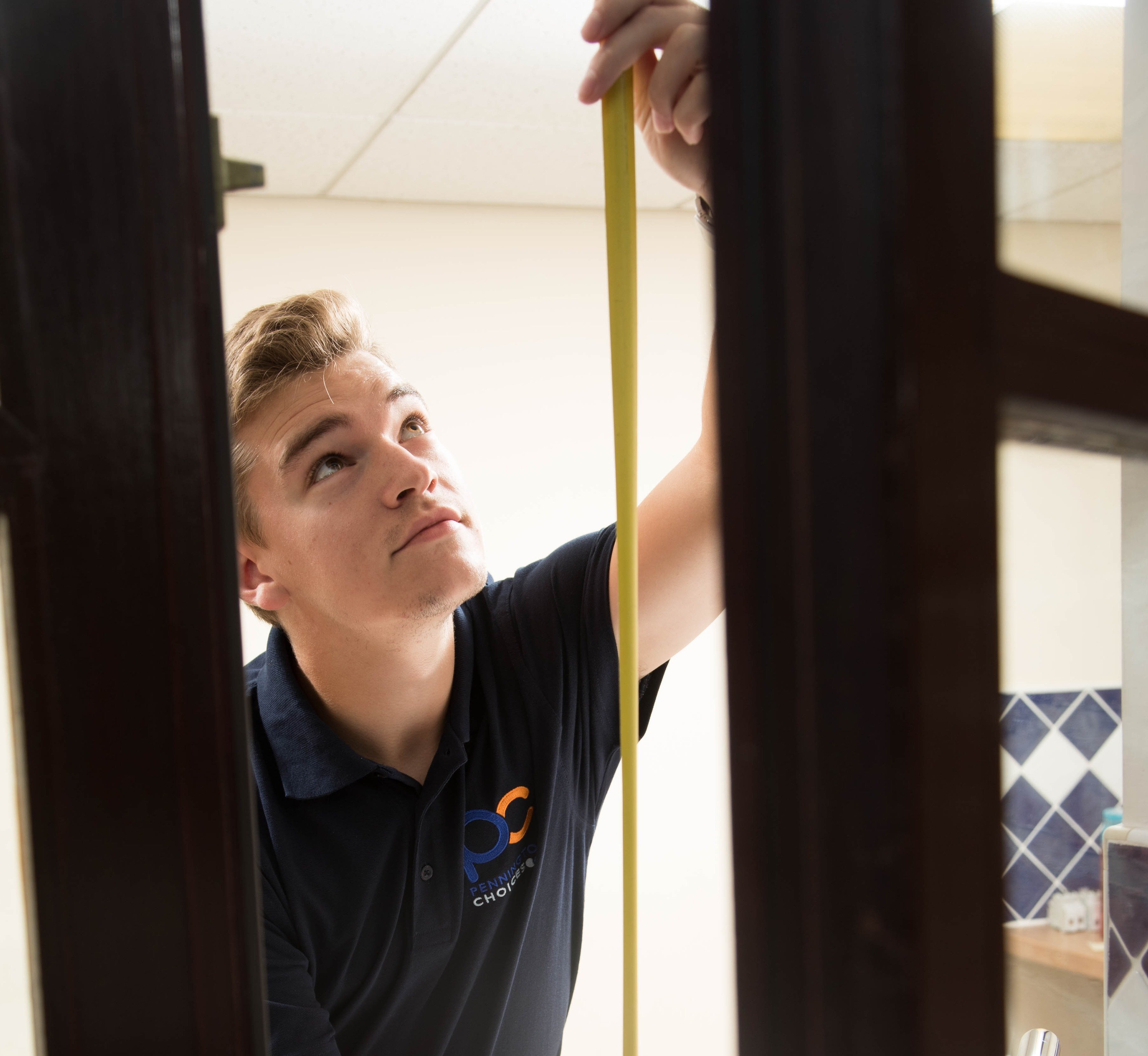 Pennington employee measuring doorframe